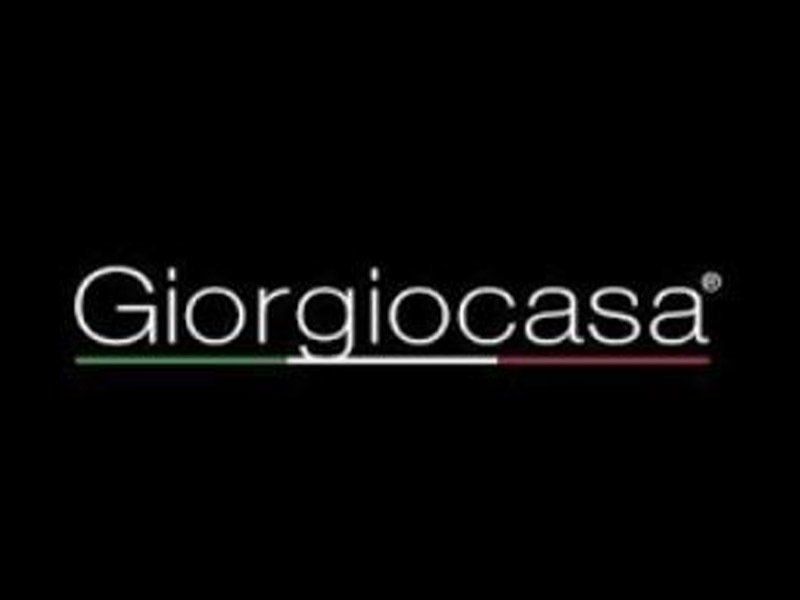 Il logo del marchio Giorgio Casa, in testo bianco su sfondo nero, è sottolineato dai colori della bandiera italiana.