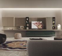 Soggiorno moderno con consolle a parete, TV, mensole a vista, illuminazione integrata e tappeto a motivi geometrici.