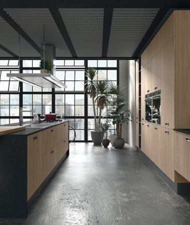 Cucina moderna con mobili in legno chiaro, un'isola scura e ampie finestre in stile industriale con vista sullo skyline della città.