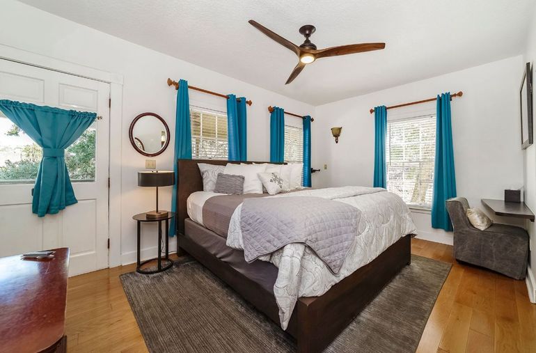 a bedroom with a large bed and a ceiling fan