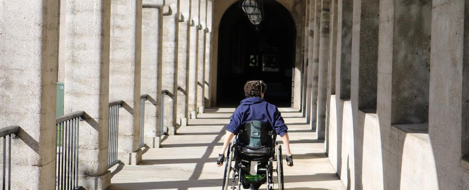 a person in a wheelchair is going down a hallway .