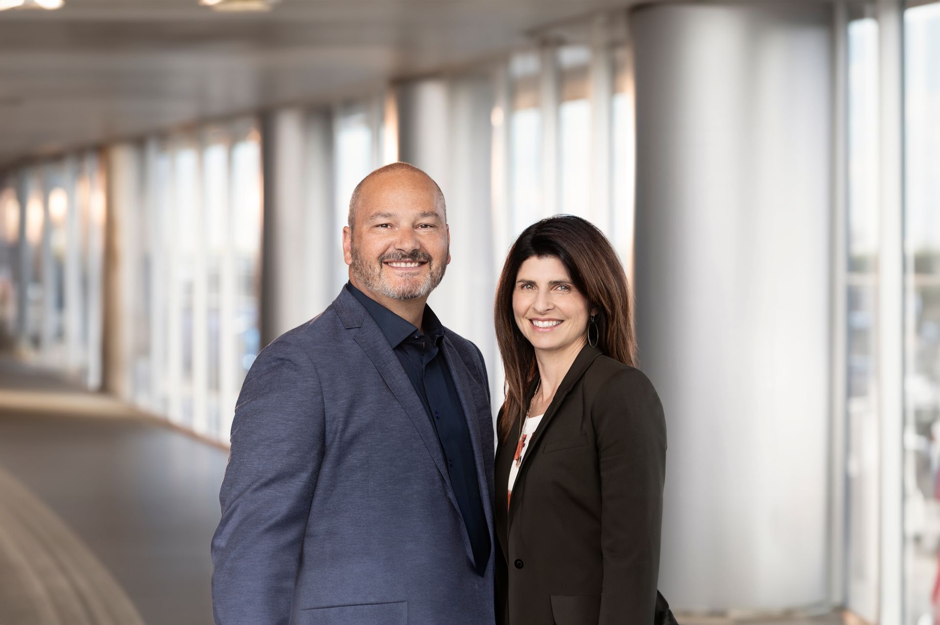 A man and a woman are standing next to each other in a hallway.