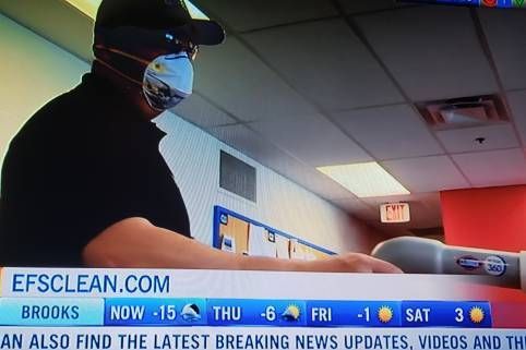 A man wearing a mask is on a news channel