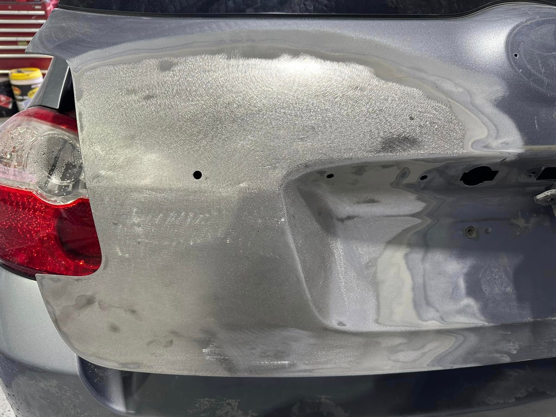 A close up of the back of a car with a damaged bumper.