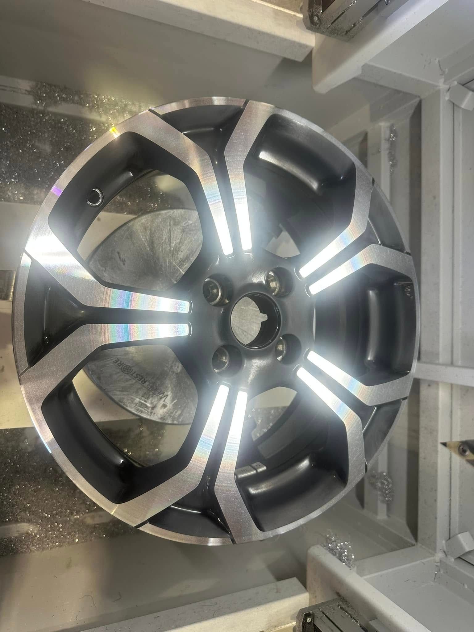 A close up of a car wheel sitting on top of a table.