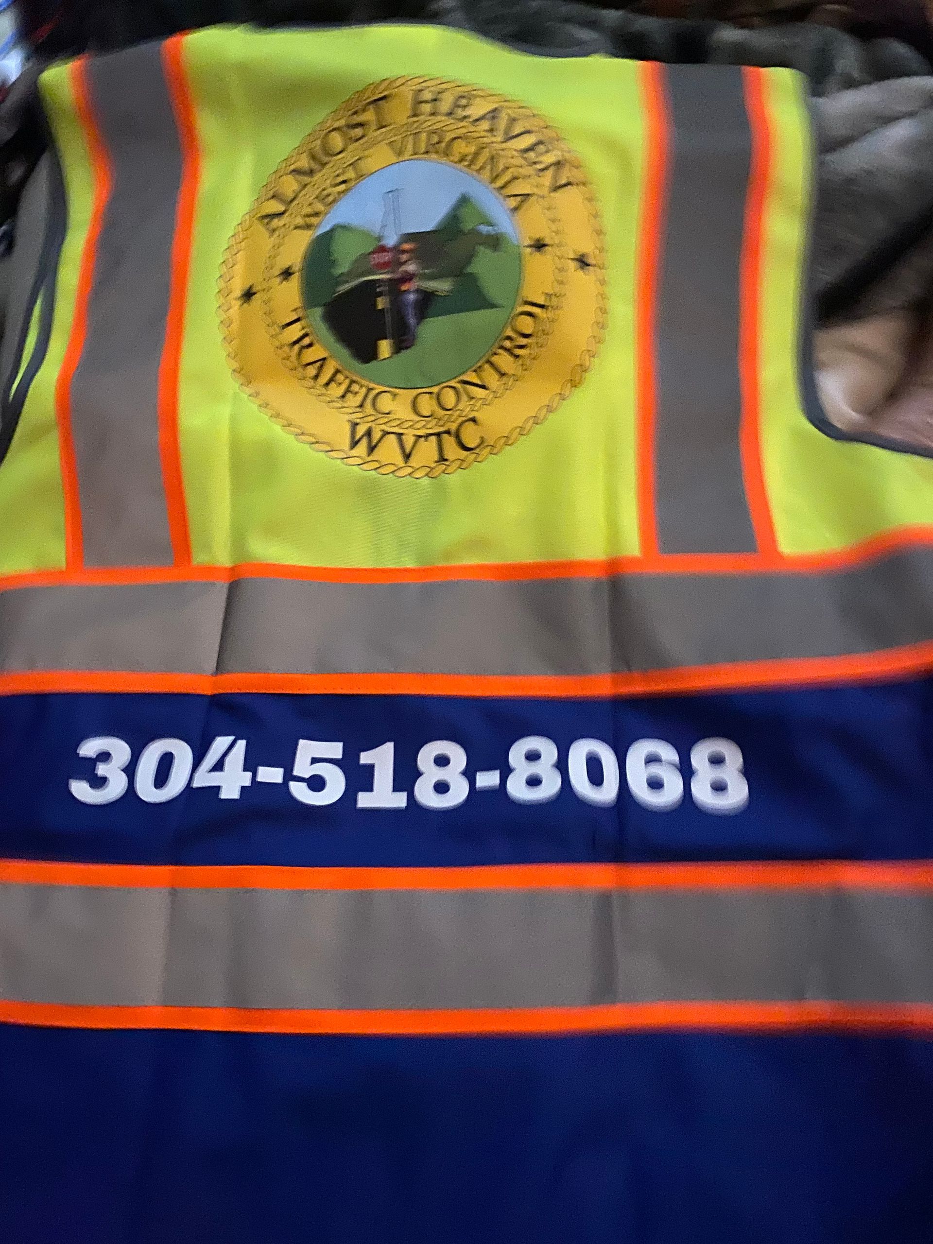Reflective safety vest with Lost River Utilities logo and phone number 304-518-8068 on blue background
