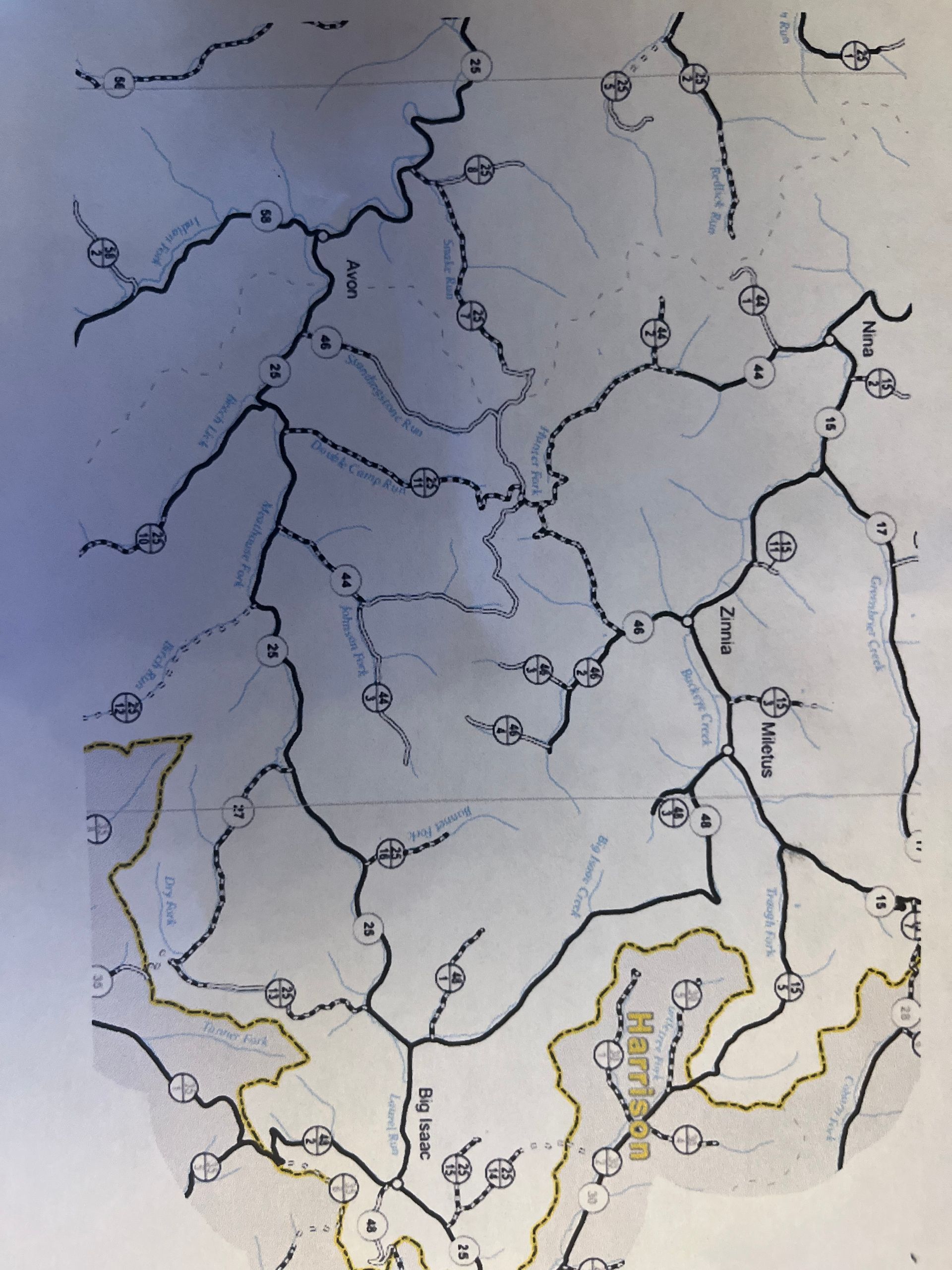 Hand-drawn map with winding black roads, blue shaded area on left, and yellow outline at bottom right