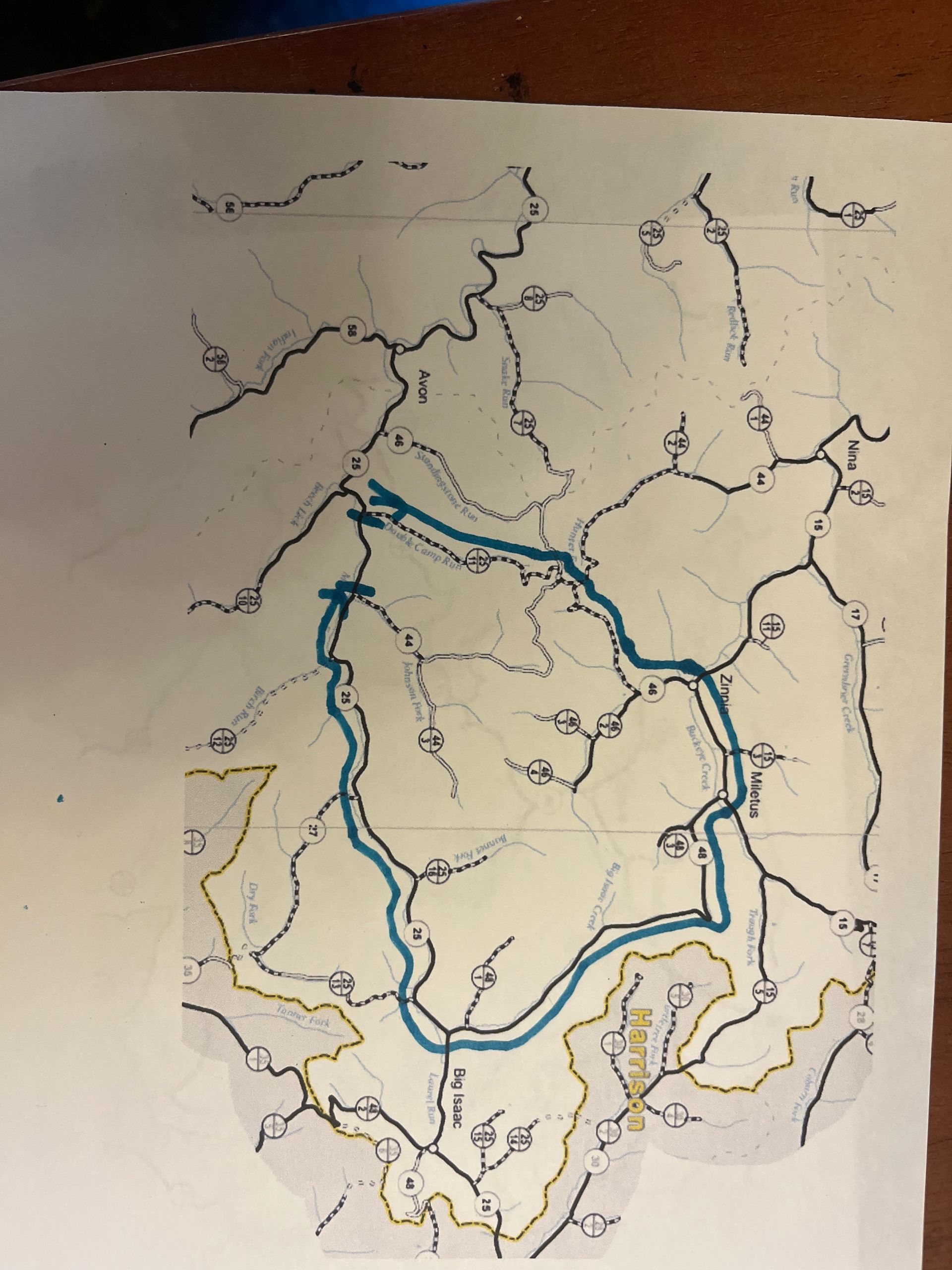 Hand-drawn map with blue highlighted route looping through a region, accented by black and yellow boundaries.