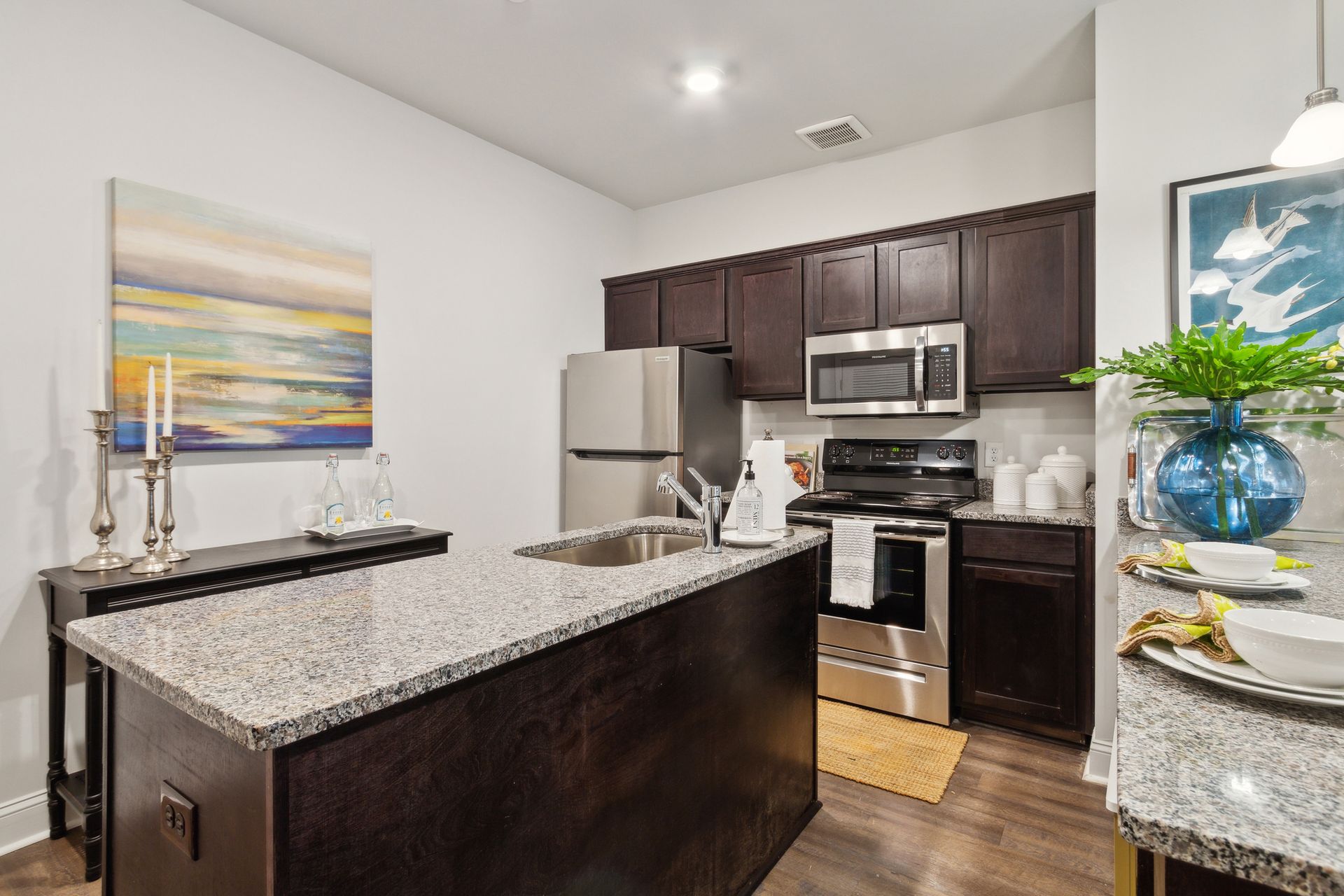 Open concept kitchen with stainless appliances and granite countertops