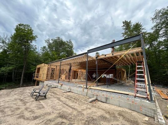Chantier de construction d'une structure métallique. Poutres en bois et supports métalliques. Ciel nuageux.