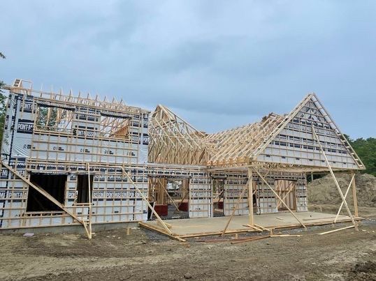 Charpente d'une maison neuve en construction par temps nuageux.