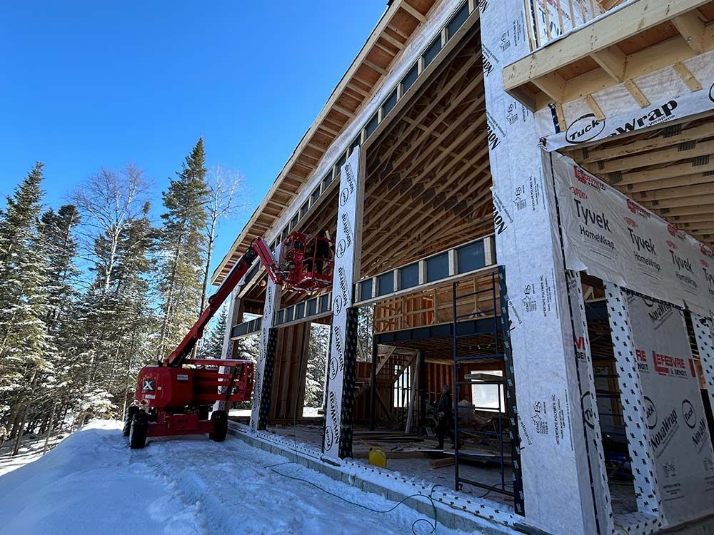 Construction de l'extérieur d'un bâtiment avec ascenseur dans un environnement enneigé.
