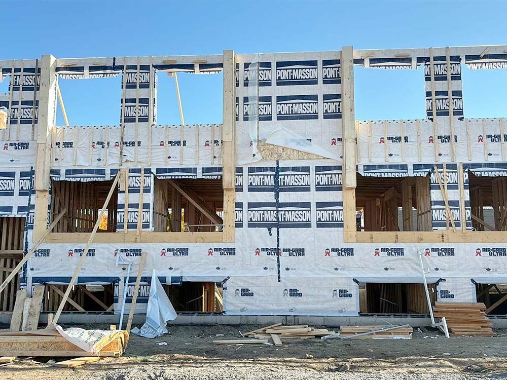 Ossature d'un bâtiment en construction, montrant les ouvertures des fenêtres et des murs.