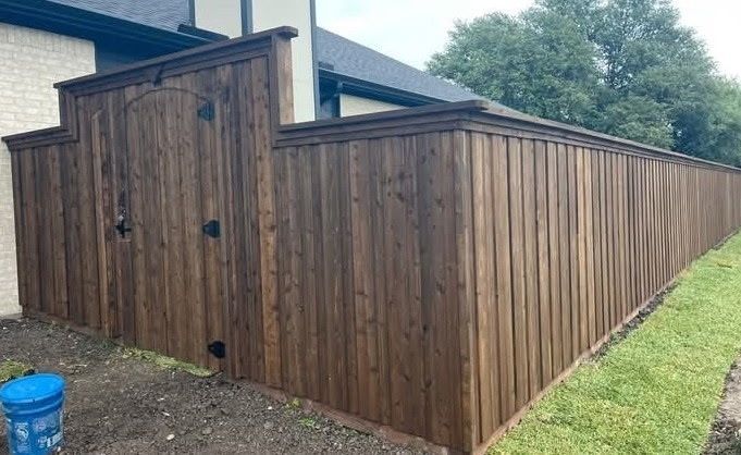 Wooden backyard storage shed with vertical plank siding and a sloped roof beside a house