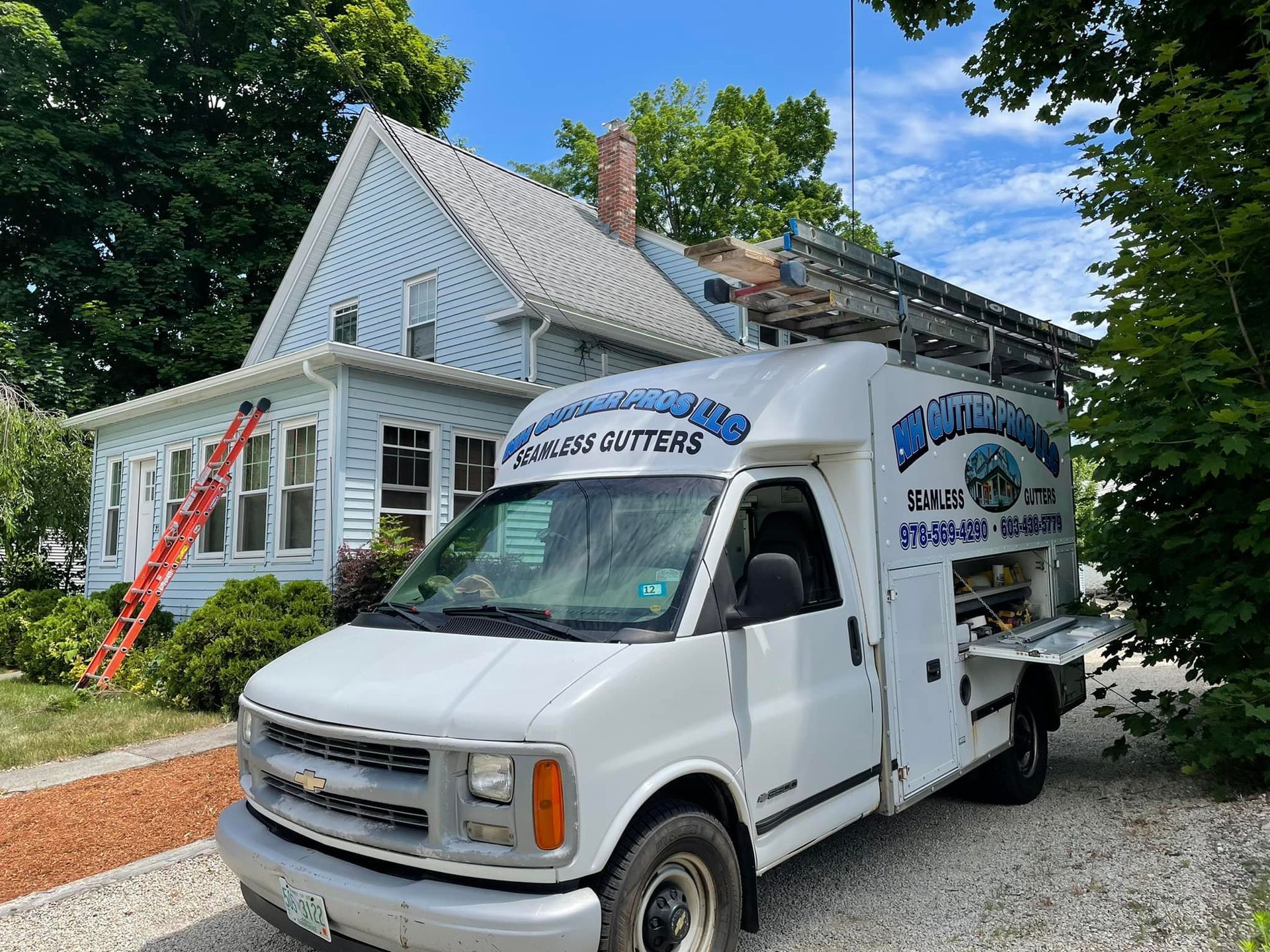 A white van is parked in front of a house.