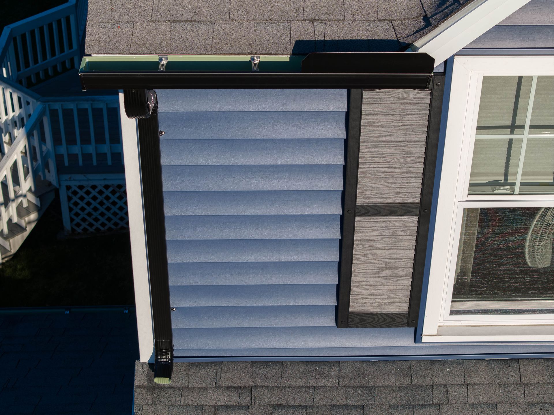 An aerial view of a house with blue siding and a window