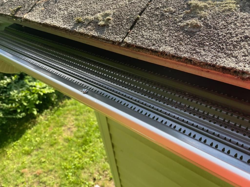 A close up of a gutter on the roof of a house.