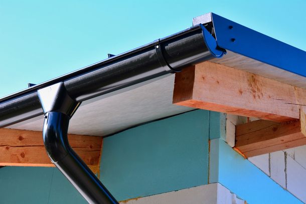 A close up of a gutter on the side of a building.