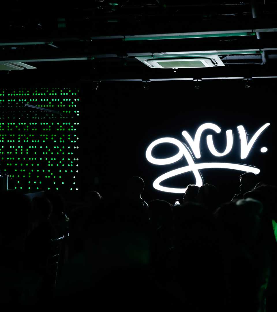 Um grupo de pessoas está em frente a uma placa que diz gruv