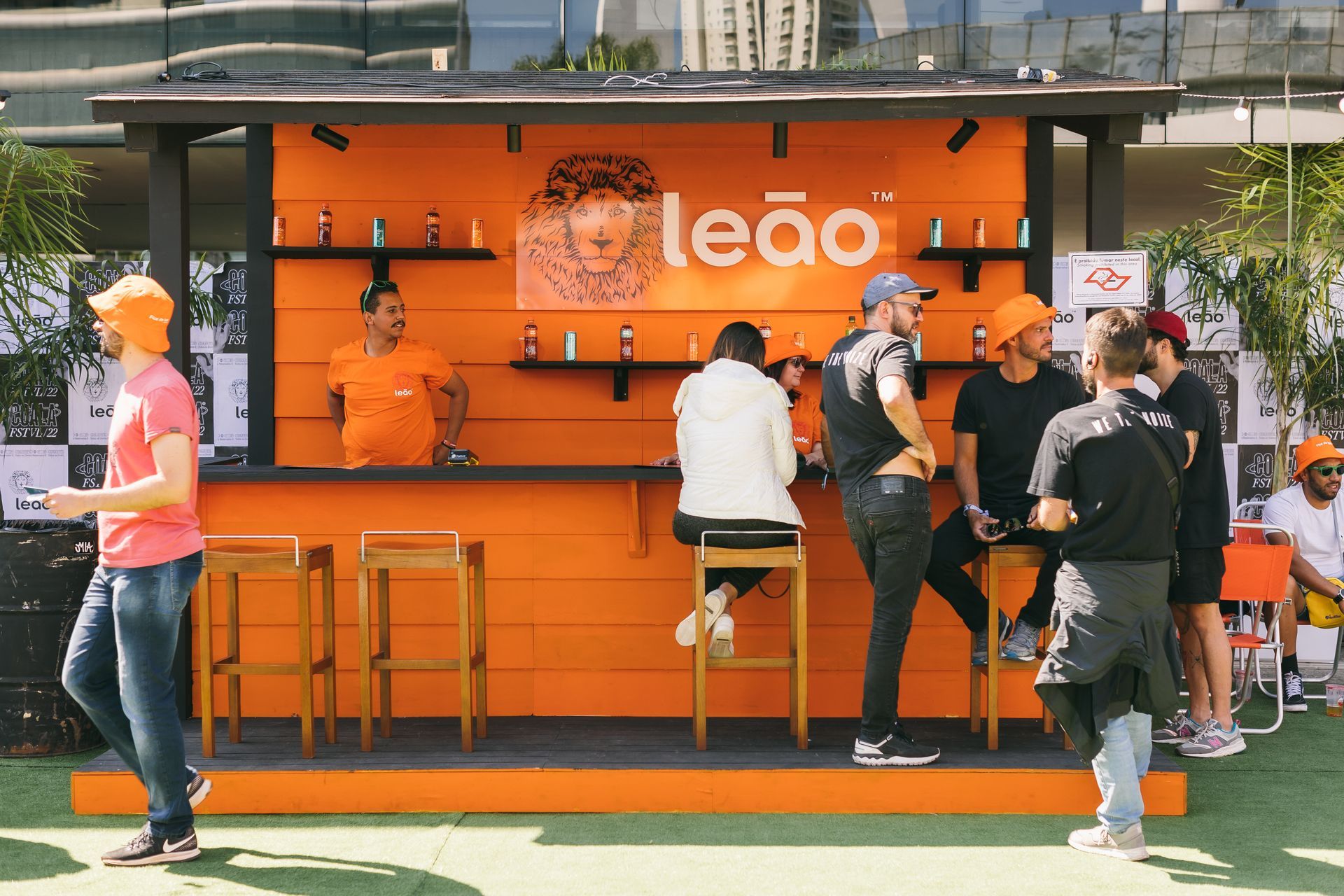 Um grupo de pessoas está em frente a um prédio laranja que diz leao