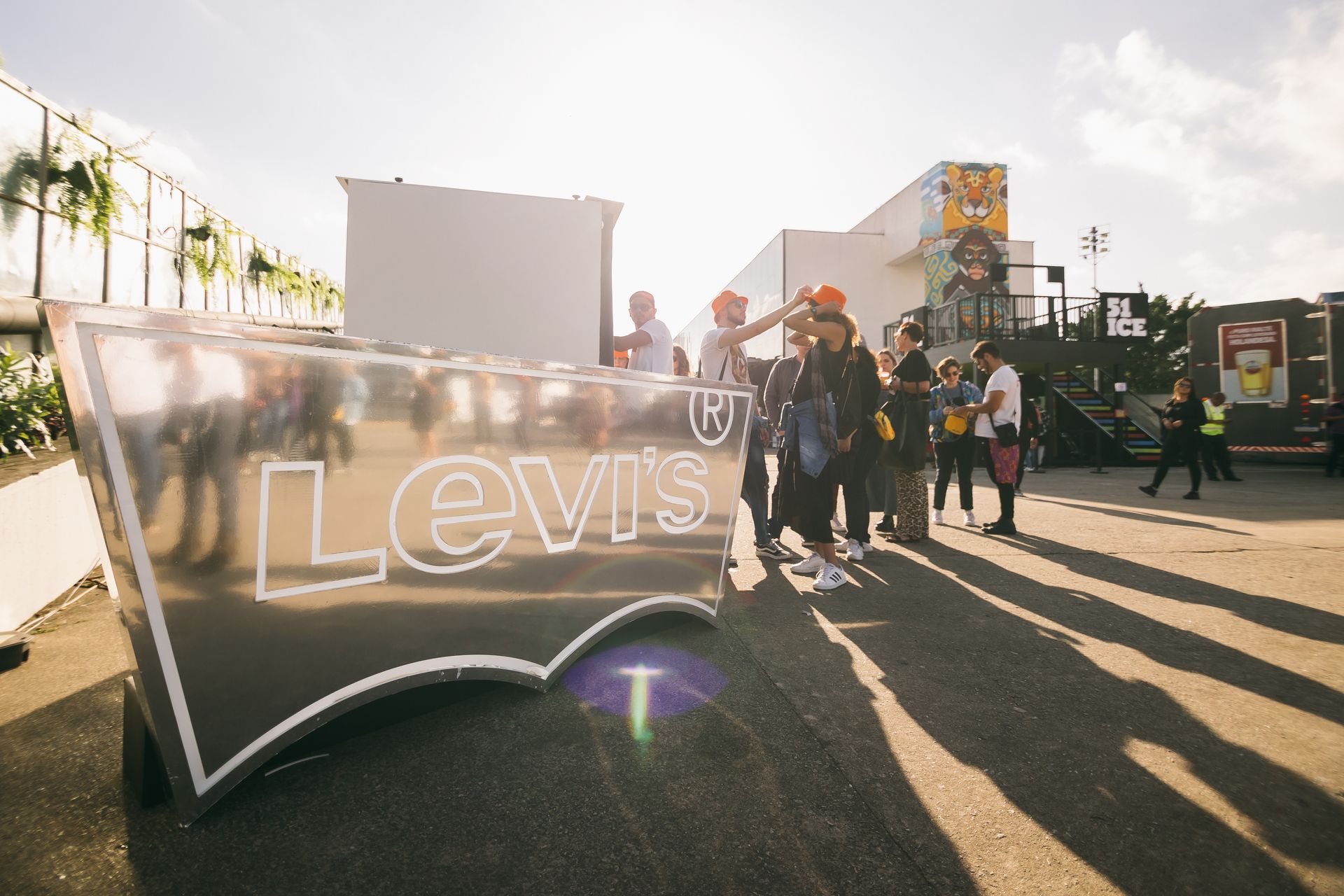 Um grupo de pessoas está em frente a uma grande placa da Levi's.