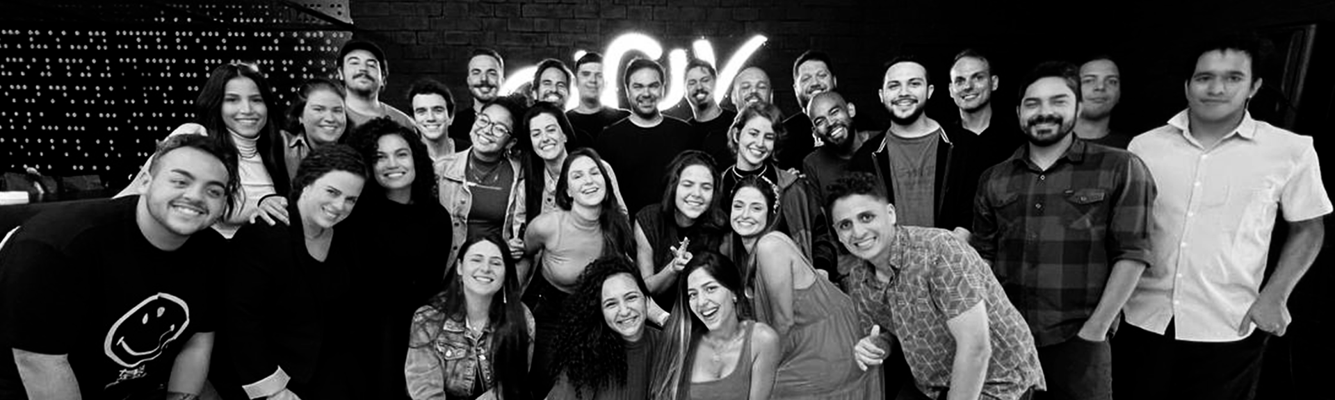 Um grupo de pessoas está posando para uma foto em preto e branco.