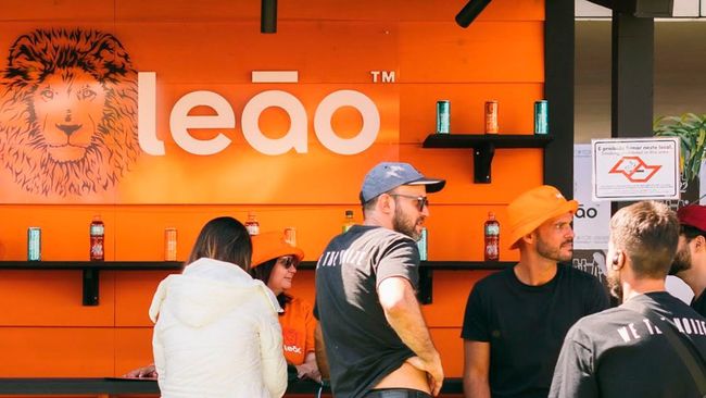 Um grupo de pessoas está em frente a um prédio laranja com a palavra leao escrita nele.