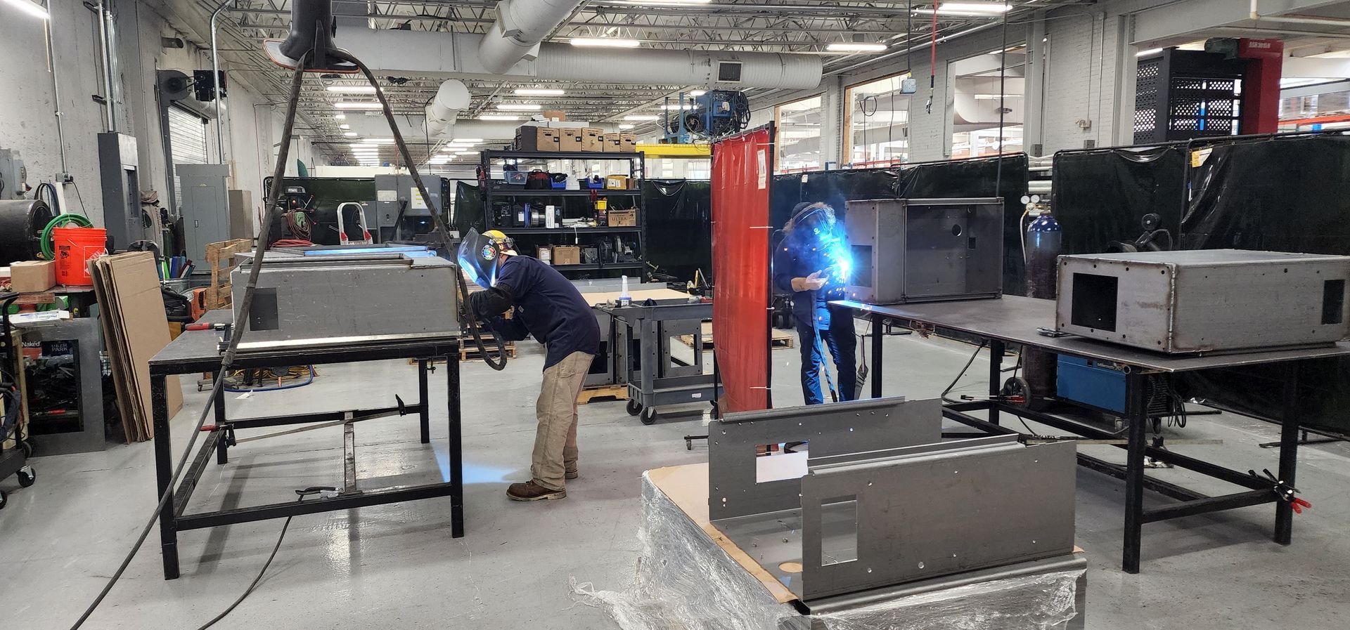 A man is welding a piece of metal in a factory.