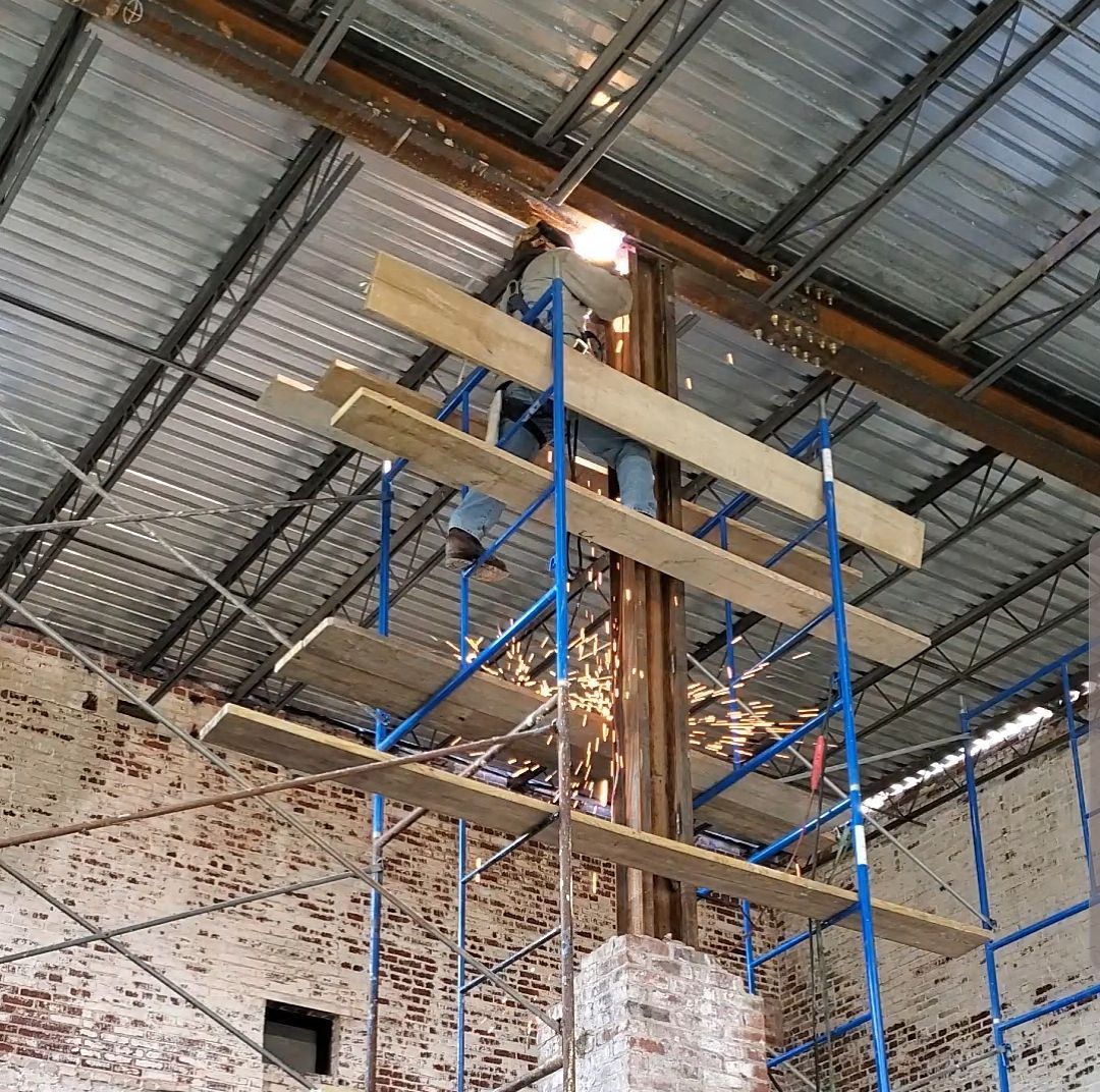 A man is standing on a scaffolding in a building