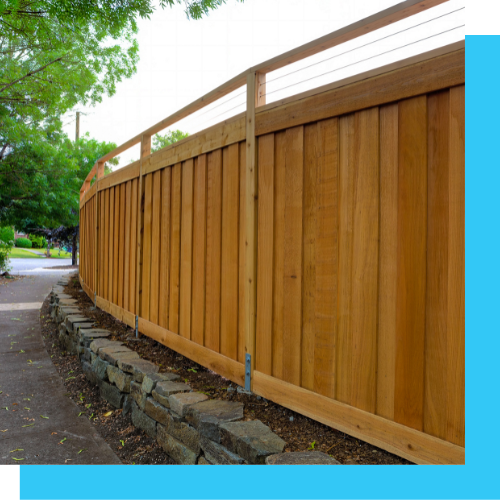 a wooden fence is sitting next to a stone wall .