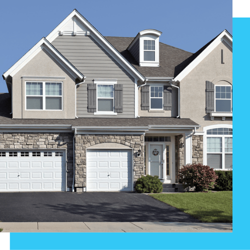 a large house with two garage doors and a blue sky in the background