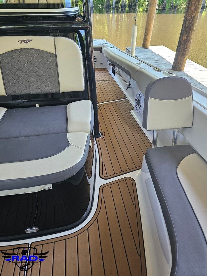 A boat with a gray and white seat and a wooden deck