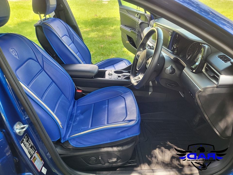The interior of a blue car with blue seat covers