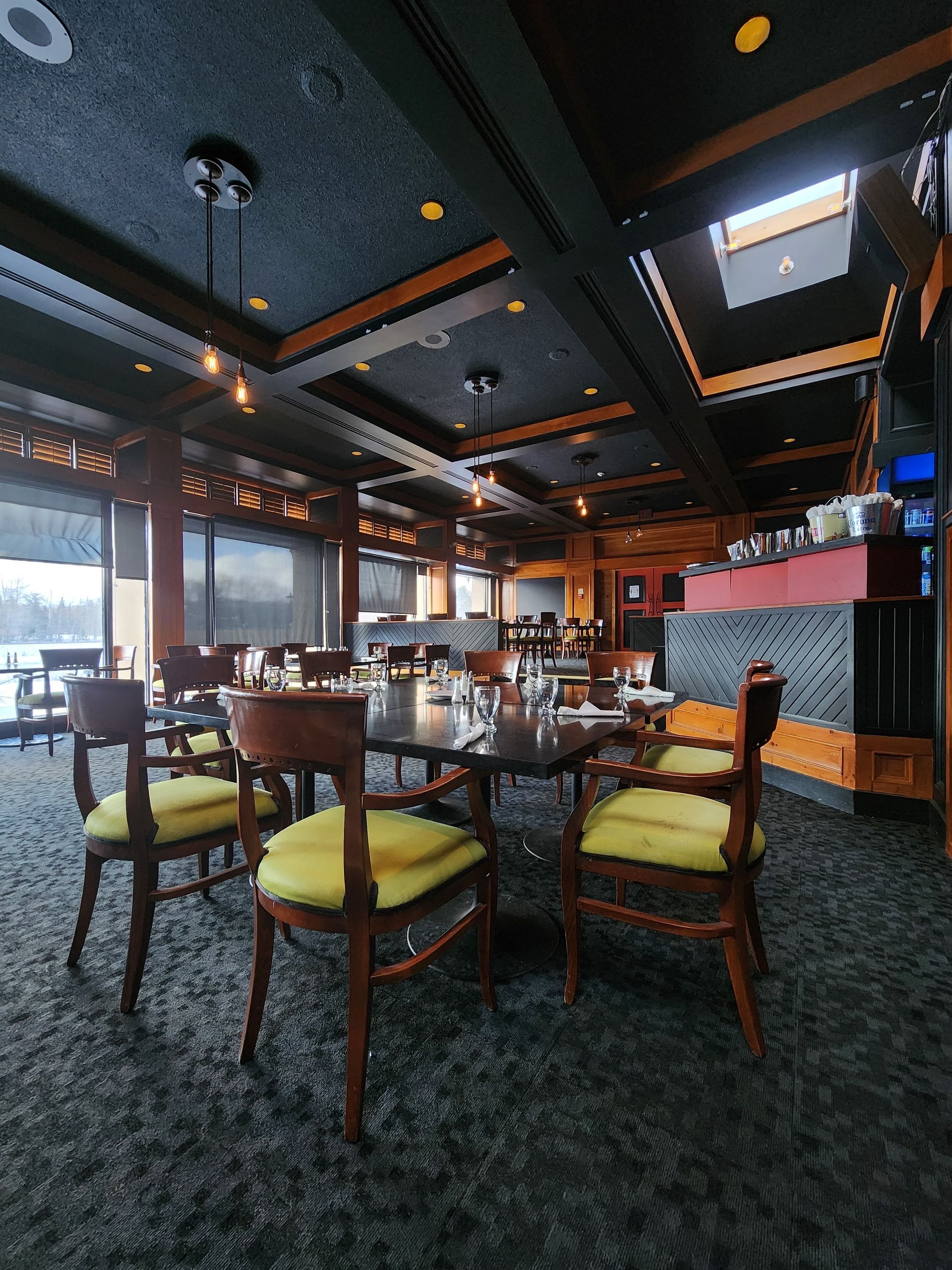 A restaurant with tables and chairs and a skylight on the ceiling