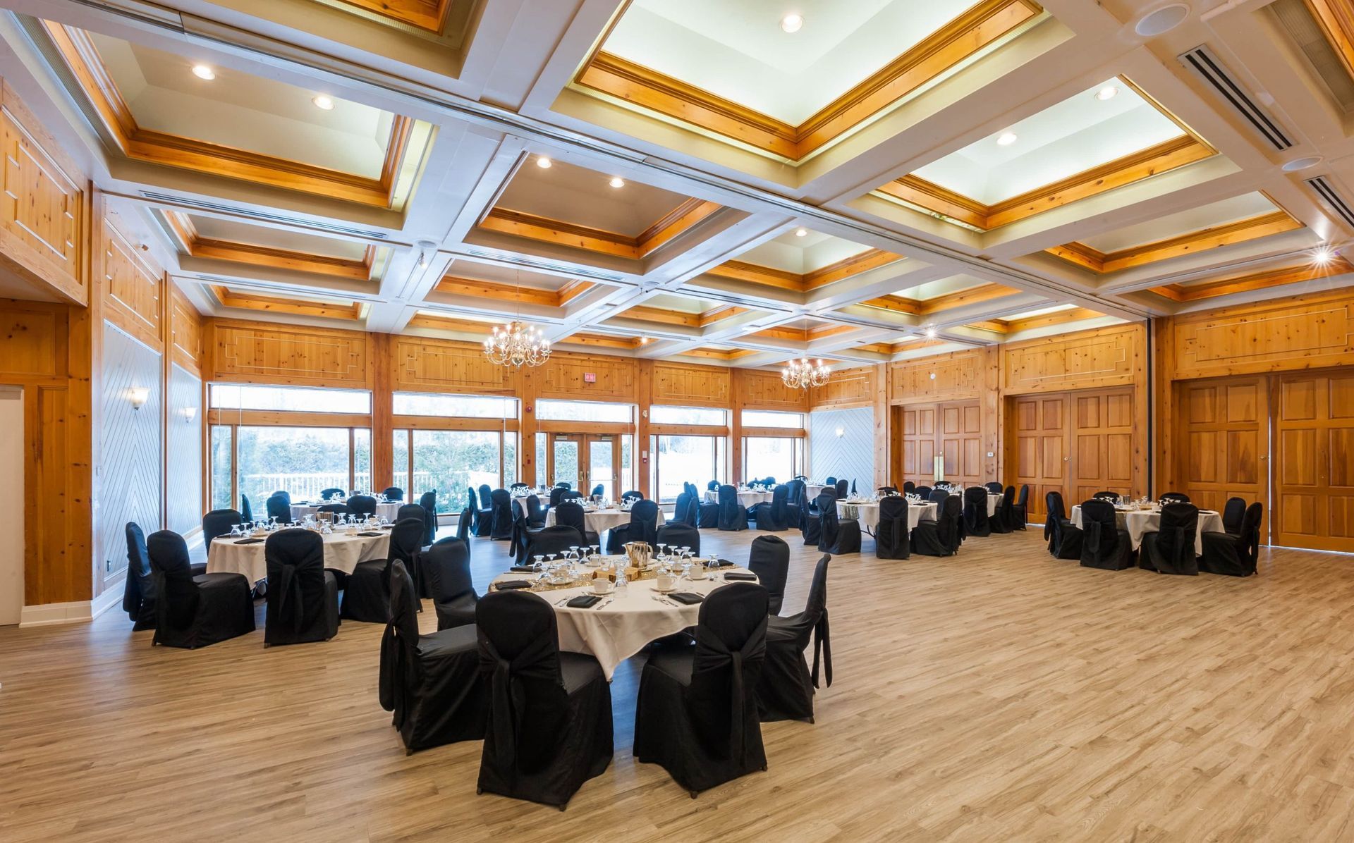 A large room with tables and chairs set up for a wedding reception.