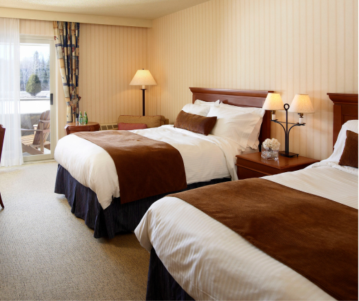 A hotel room with two beds and a sliding glass door
