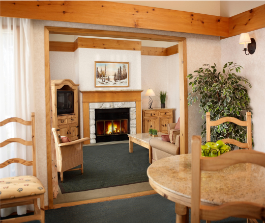 A living room with a fireplace and a table and chairs