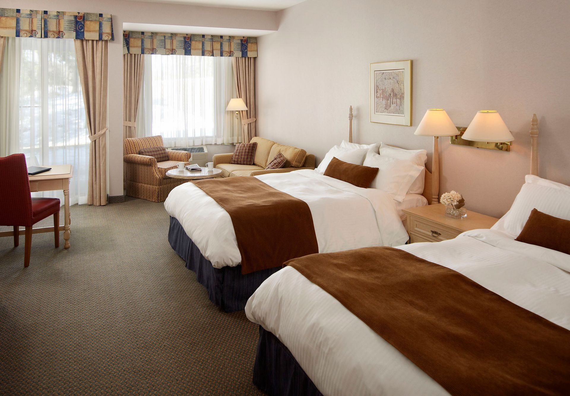 A hotel room with two beds and a couch