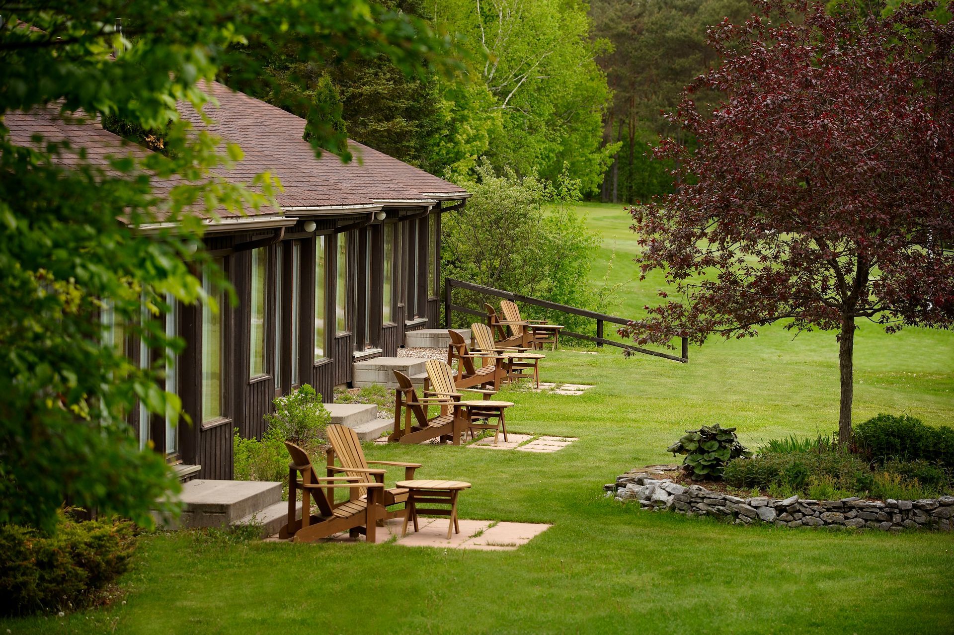 A row of chairs are lined up in front of a house.