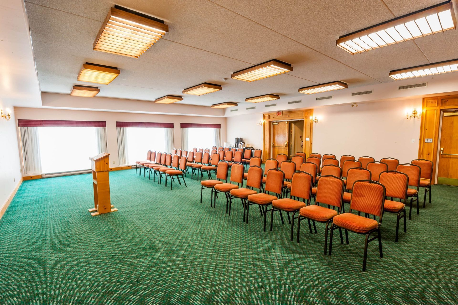 A large conference room with rows of chairs and a podium.