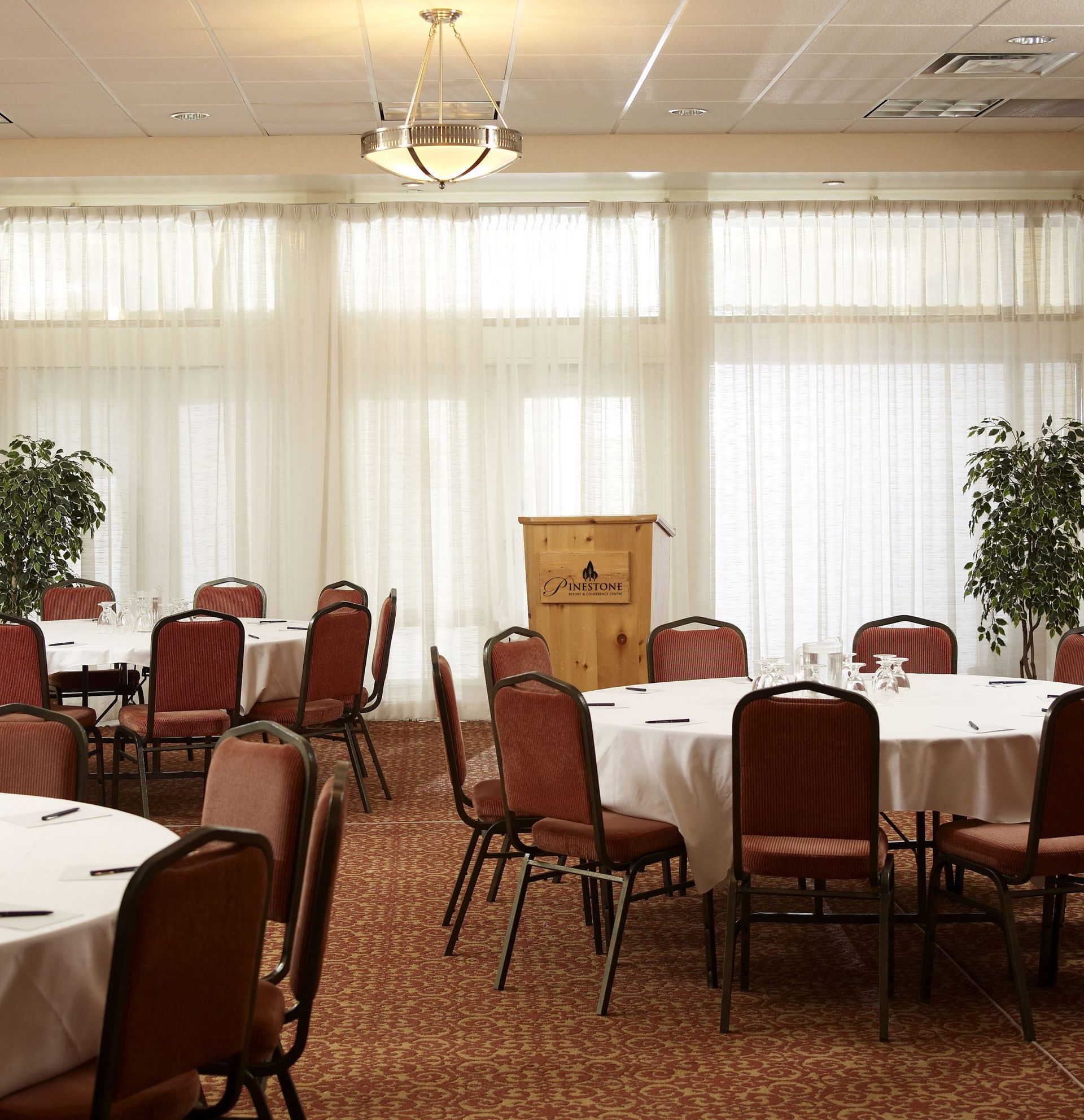 A large room with tables and chairs and a podium