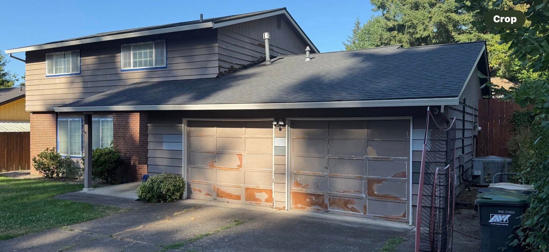 Suburban two-story house with brick and siding exterior, attached double garage, and driveway in front