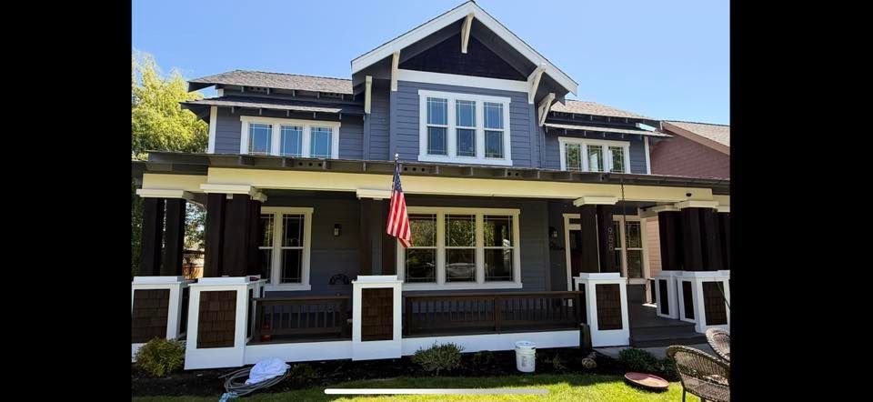 Two-story house with porch, white trim, and an American flag hanging at the front