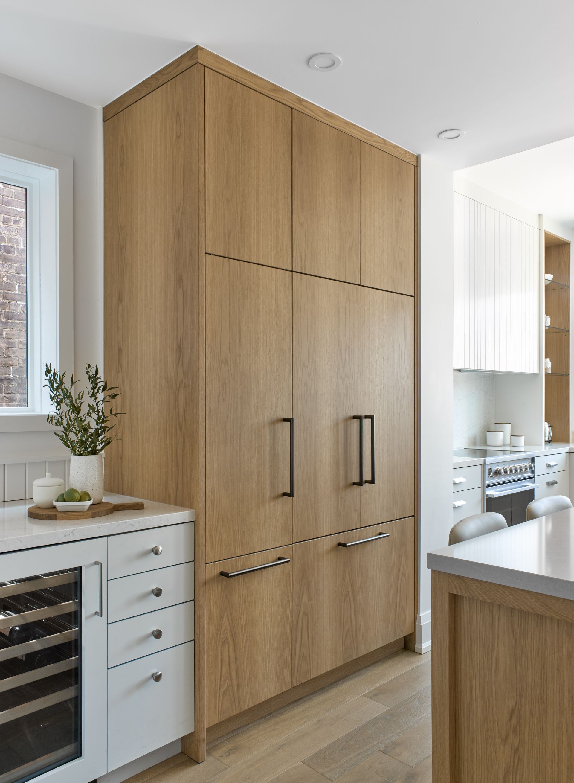 A kitchen with wooden cabinets and white cabinets
