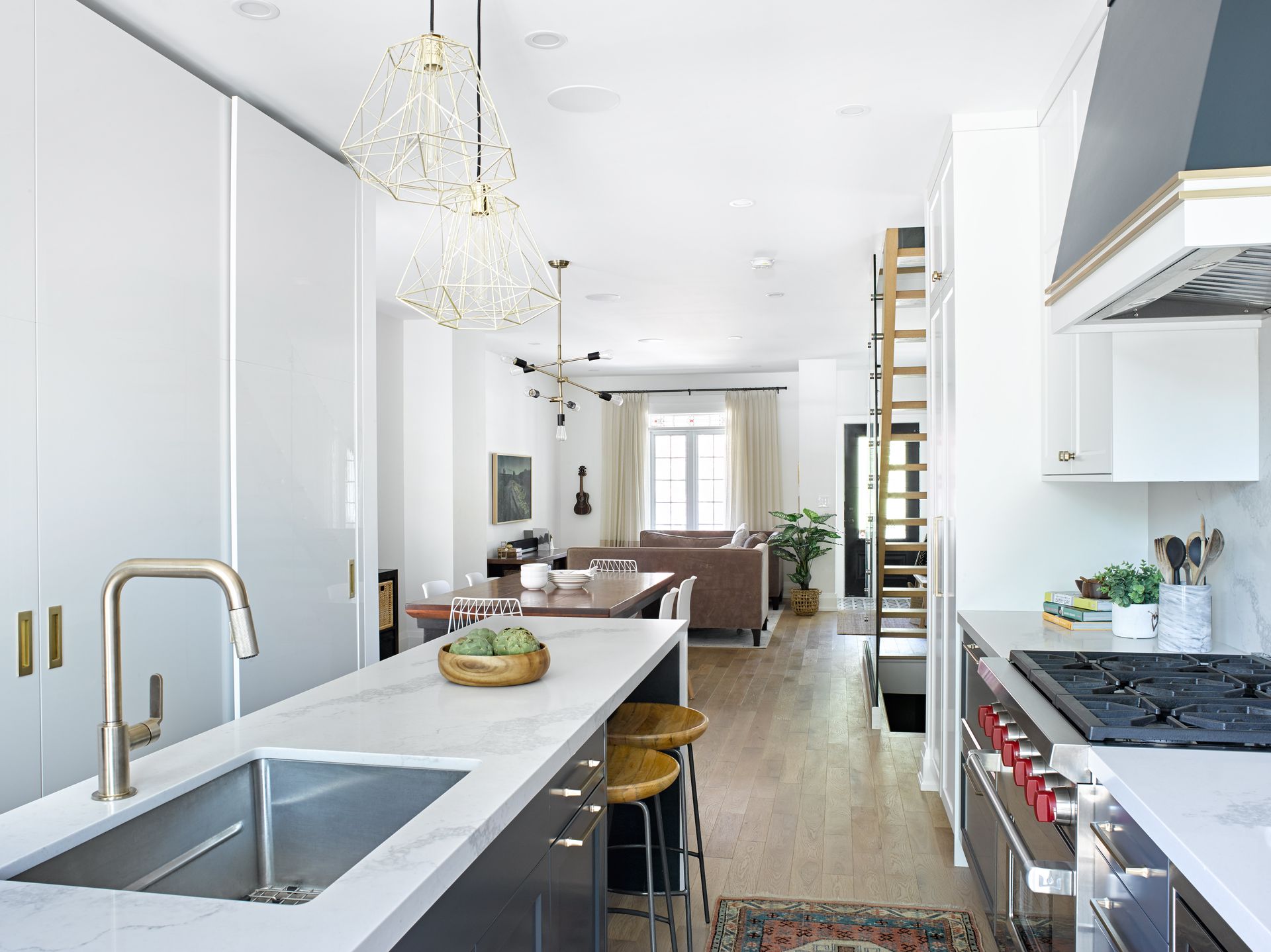 A kitchen with a sink , stove , and stools