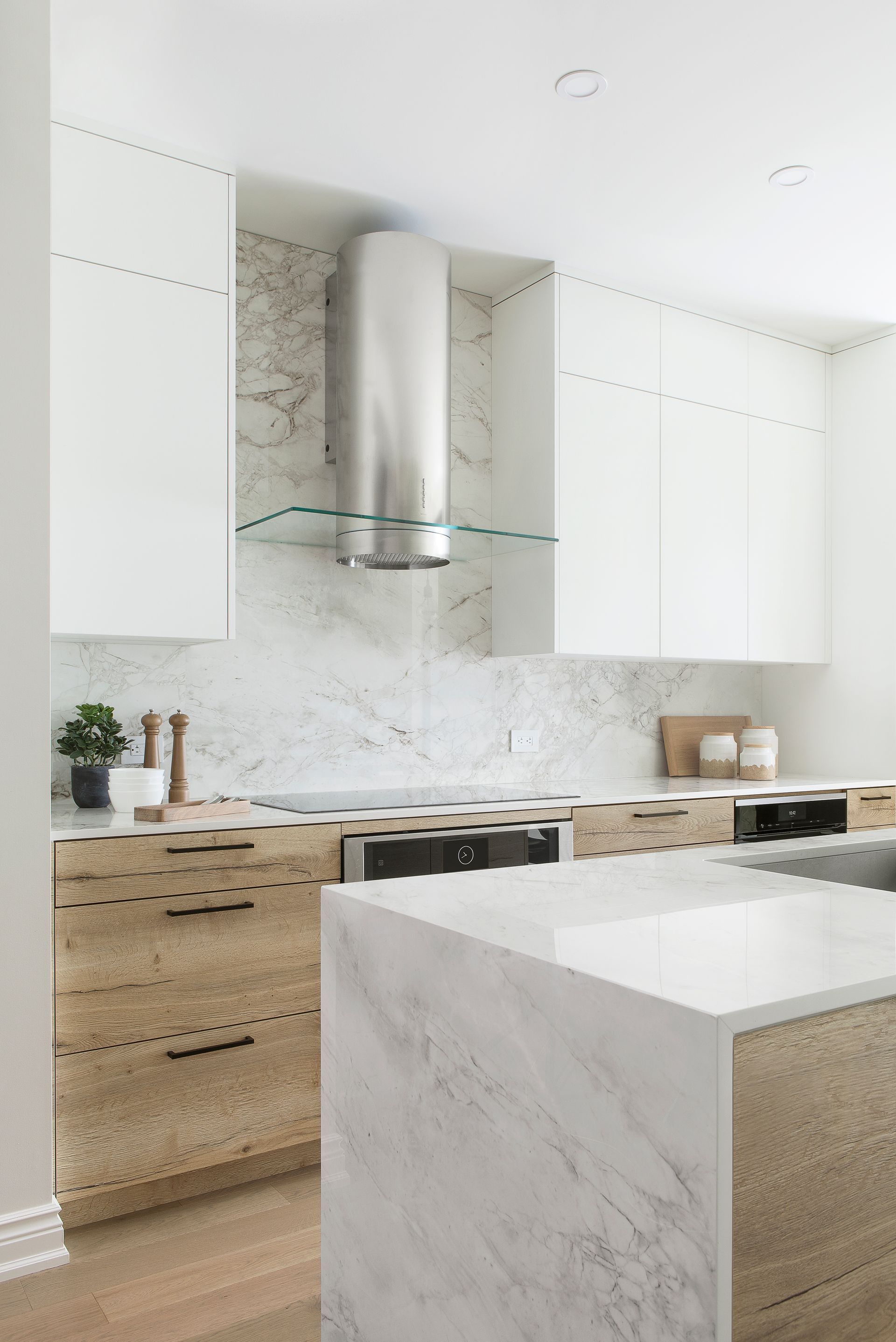 A kitchen with stainless steel appliances and marble counter tops.