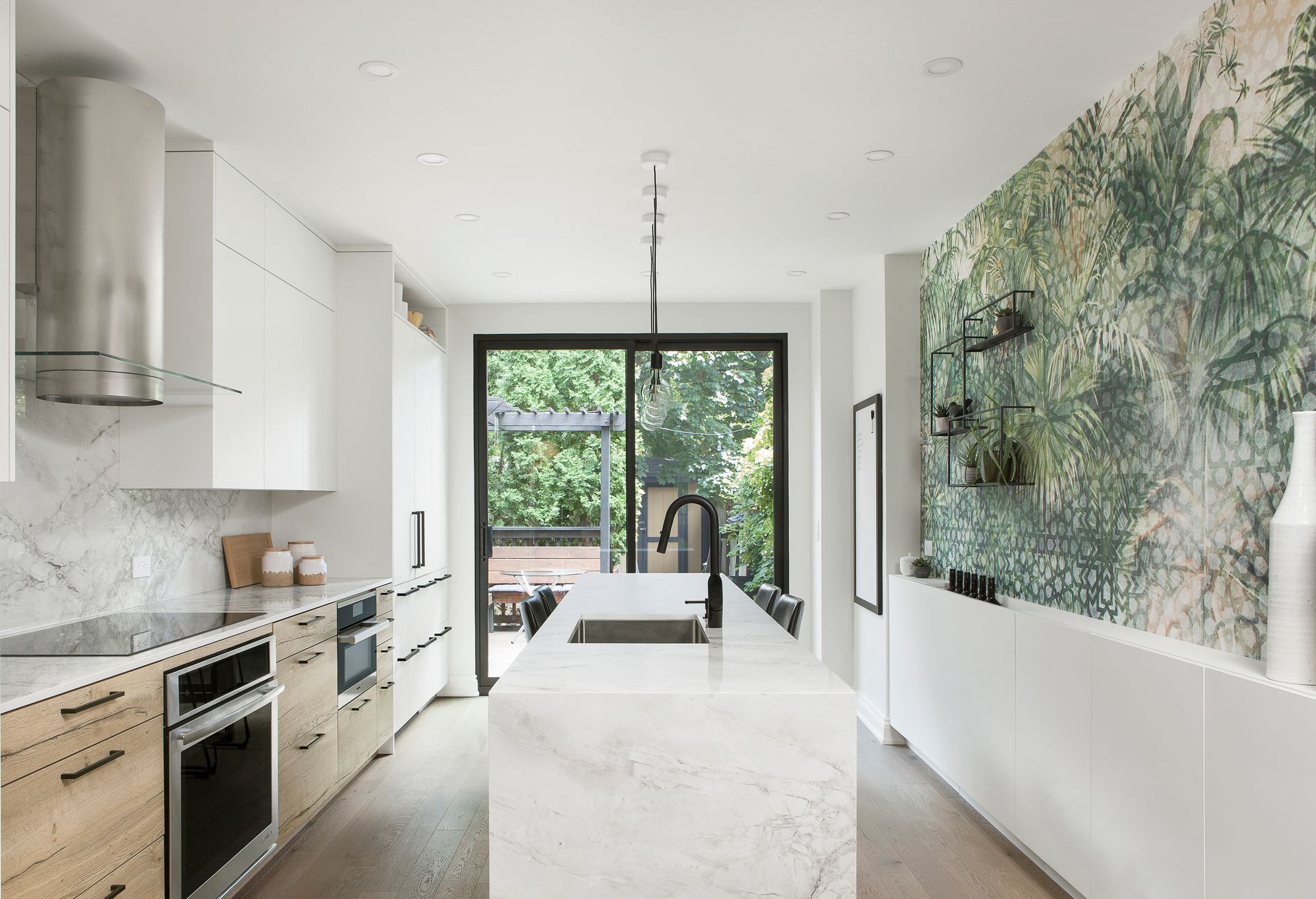 A kitchen with white cabinets , stainless steel appliances and a large island.