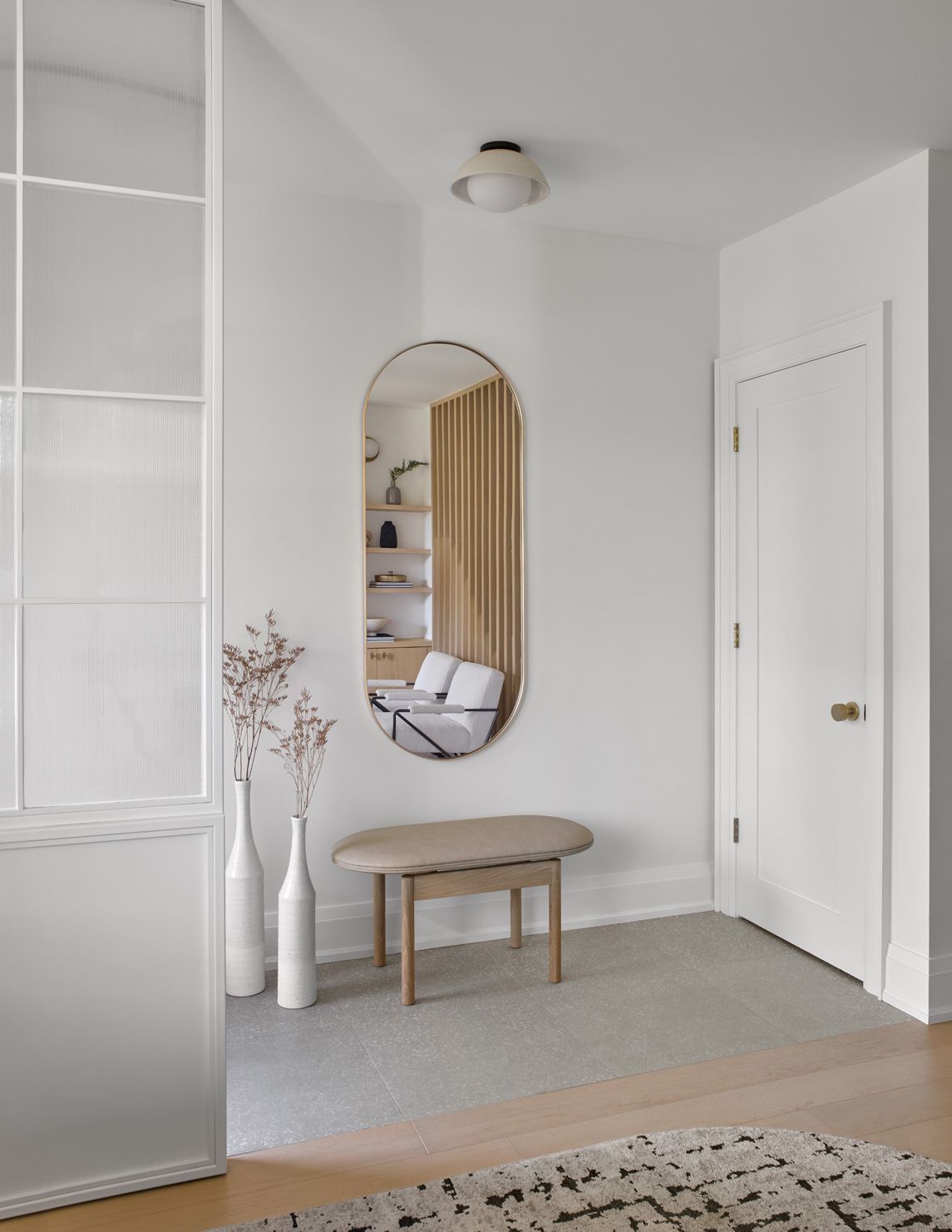 A hallway with a large mirror and a bench