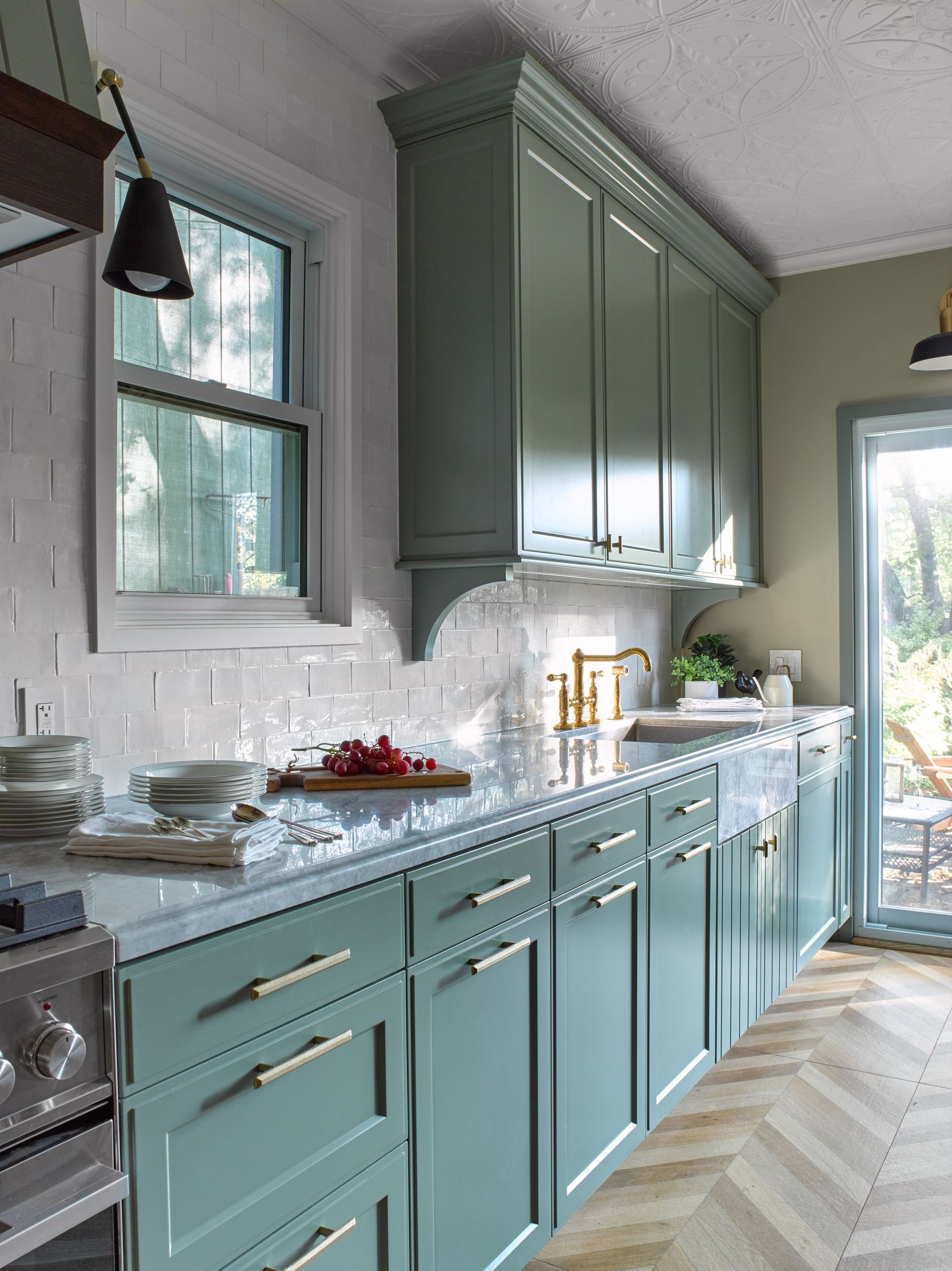 A kitchen with green cabinets and white counter tops