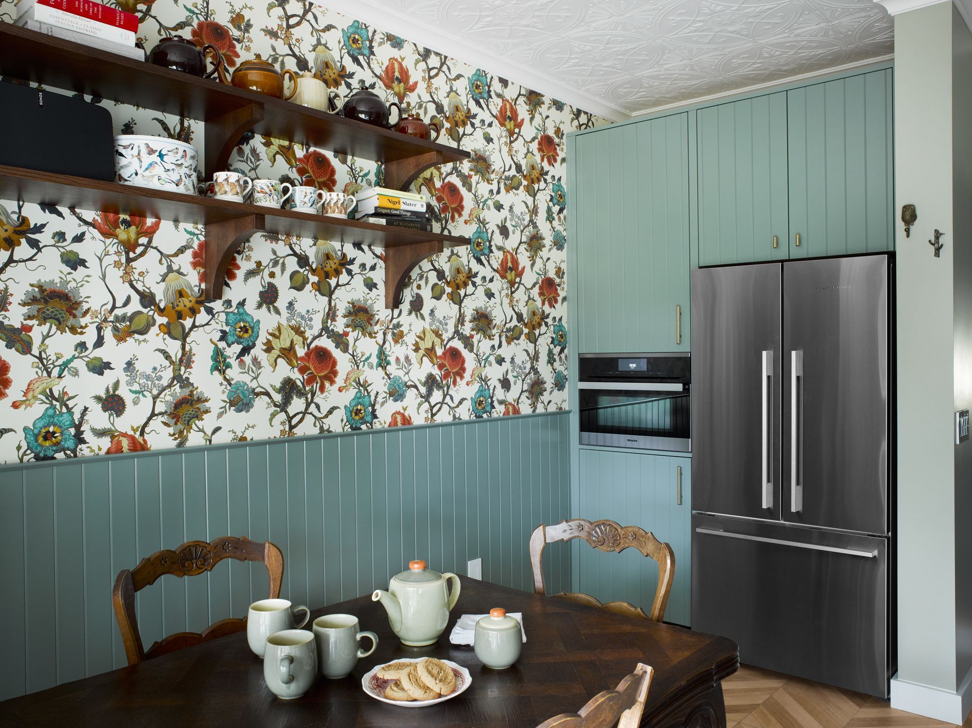 A kitchen with a table and chairs and a refrigerator.